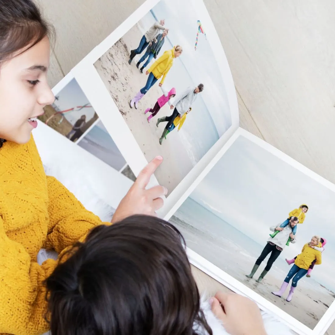 Duas crianças a folhear um álbum impresso